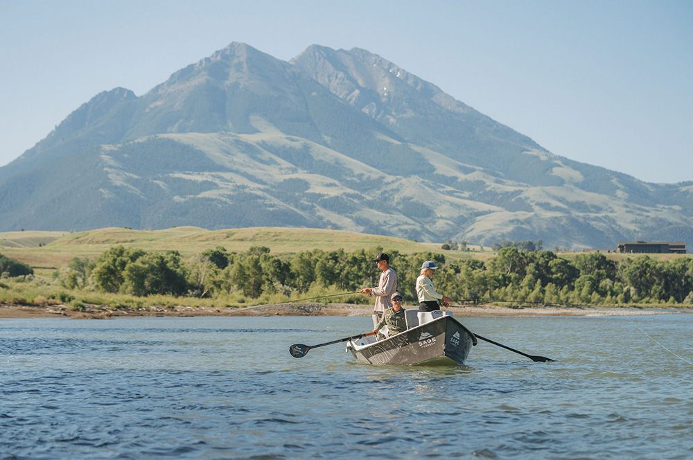 Fly fishing in a drift boat with Emigrant Peak in the background.