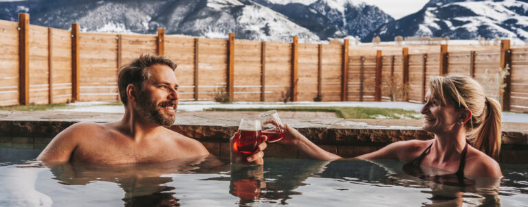 man and woman toasting in hot tub
