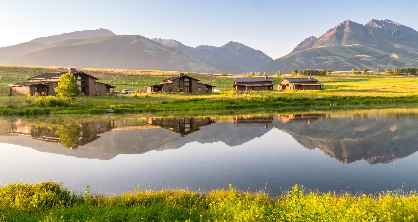 https://sagelodge.com/wp-content/uploads/2023/04/1440x750-pond-view-of-the-ranch-houses-with-mountains-and-fields-Sage-Lodge-during-the-summer-Montana-Luxury-Hotel-near-Yellowstone-National-Park.jpg