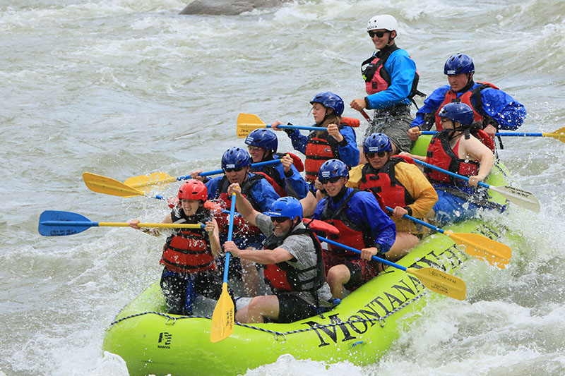 Group of people river rafting.