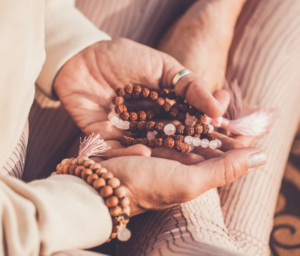 Woman holding Mala bracelets.