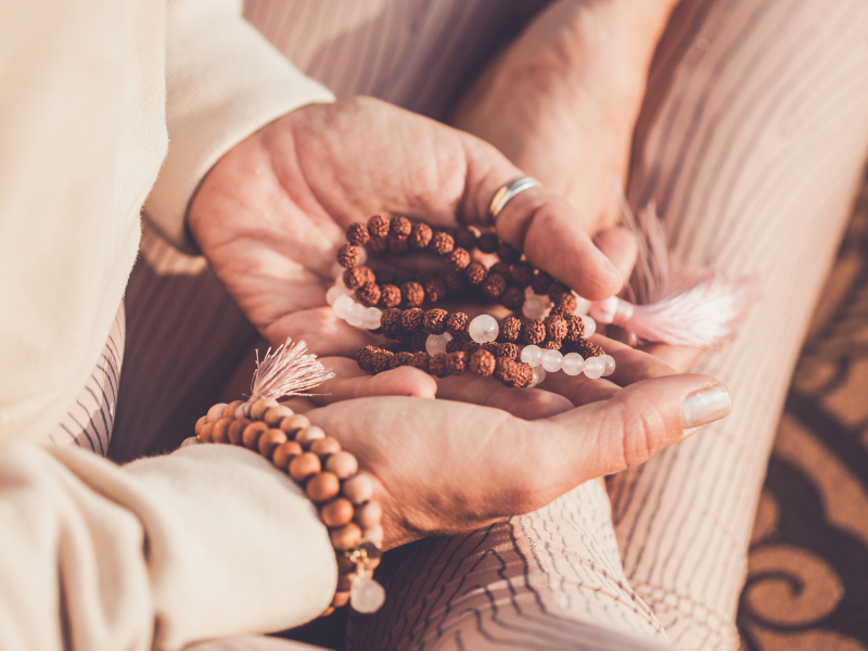 Woman holding Mala bracelets.