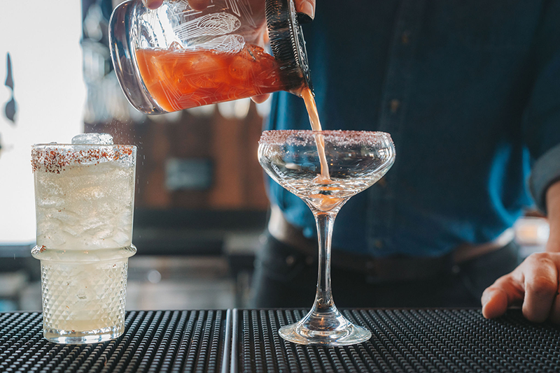 Bartender pouring a cocktail.